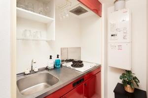 a kitchen with red cabinets and a sink at Shirogane Apartment in Tokyo +16 photos