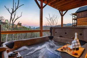 a jacuzzi tub with a table and wine glasses at Metal Manor in Gatlinburg