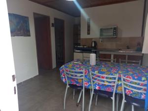 a dining room with a table with chairs and a kitchen at Cabañas del Valle JONIVA in Termas de Río Hondo
