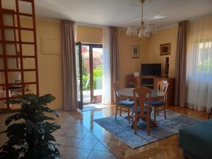 ein Wohnzimmer mit Tisch und Stühlen und einem Fernseher in der Unterkunft Apartments with parking spaces Zadar - Diklo, Zadar - 5809 in Zadar + 16 Fotos