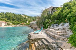 a group of chairs sitting on the side of a river at Apartments by the sea Cove Donja Kruscica - Donja Krusica, Solta - 11146 in Grohote