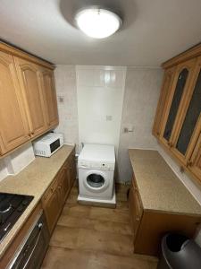 una cocina con lavadora y microondas en Tanners End Apartment, en Edmonton