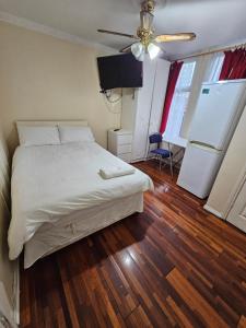 Un dormitorio con una cama y un ventilador de techo. en Tanners End Apartment, en Edmonton 3 fotos más