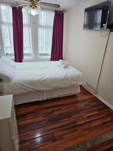 Un dormitorio con una cama y un ventilador de techo. en Tanners End Apartment, en Edmonton