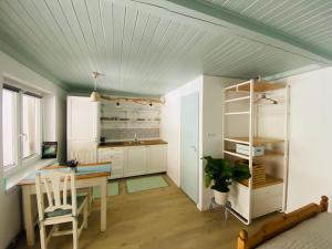 a kitchen with a desk and a table in a room at Szélcsend Apartman in Balatonföldvár