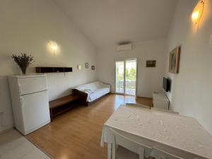 a room with a table and a refrigerator and a bed at Apartments with parking space Palit, Rab - 16356 in Mundanije