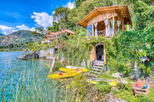 a house on the shore of a lake with kayaks at 2-story Lakefront castita, beach, kitchen, sauna in Sololá