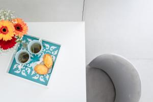 a table with a plate of food and a vase with flowers at Kairos in Torre San Giovanni Ugento