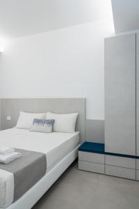 a white bedroom with a bed and a cabinet at Kairos in Torre San Giovanni Ugento +32 photos