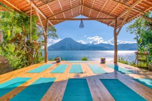 a yoga deck with a view of the water and a mountain at 2-story Lakefront castita, beach, kitchen, sauna in Sololá +31 photos