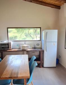 a kitchen with a wooden table and a refrigerator at Barcena Houses in Tumbaya