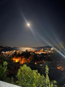 una vista de una ciudad por la noche con una luna en M&A Apartment II, en Sarandë