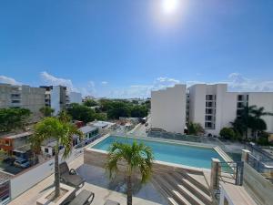 a view of a pool from the balcony of a building at Condo Kiaraluna in Playa del Carmen