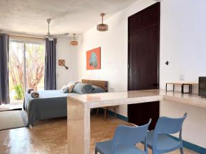 a bedroom with a bed and a table and chairs at Maralagua in Puerto Escondido
