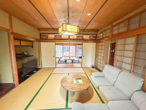 ein Wohnzimmer mit Sofa und Tisch in der Unterkunft 癒しの宿 Villa ZEN 讃岐白鳥 in Higashikagawa