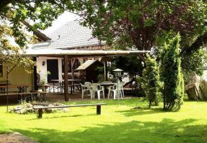 ein Haus mit einem Tisch und Stühlen im Hof in der Unterkunft Gasthaus-Pension Zum Brandweiher in Amorbach