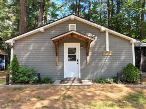 a small house with a white door in a yard at Pine Ridge Park Campground in Pembroke