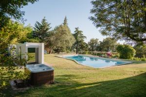 a hot tub in the grass next to a swimming pool at Casa Malcata by Portus Alacer - Quinta Fonte Fria in Carreiras