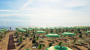 a bunch of green umbrellas on a beach at Hotel Mare Blu -- boutique in Pineto