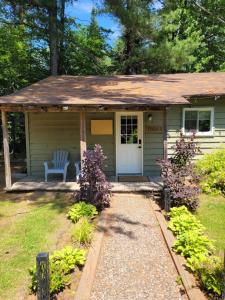 a small green house with a white door at Pine Ridge Park Campground in Pembroke