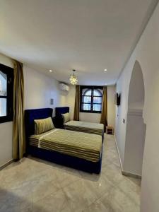 a bedroom with two beds and a window at Dar Larbi in Chefchaouen +23 photos