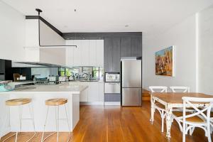 a kitchen with a wooden table and a refrigerator at Charming 3BR in Top Spot in Sydney +23 photos