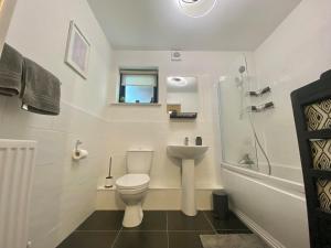 a white bathroom with a toilet and a sink at Modern 2 Bed apartment w parking in Belfast