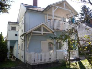 ザラカロシュにあるApartment in Zalakaros - Thermalbad 20674の青い家 ポーチとバルコニー付