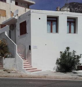 - un bâtiment blanc avec des escaliers sur son côté dans l'établissement Casa Pina, à Cala Gonone