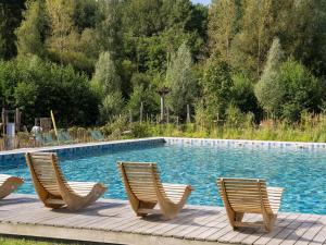 three chairs sitting next to a swimming pool at Cottage in Tournai with Forest View in Antoing +31 photos