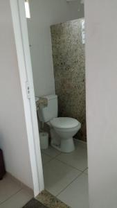 a bathroom with a white toilet in a room at Suites de frente pra praia in Itapemirim