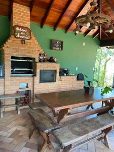a dining room with a table and a fireplace at Refúgio das Araucárias in Campos do Jordão