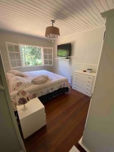 a bedroom with a bed and a tv in it at Refúgio das Araucárias in Campos do Jordão +62 photos
