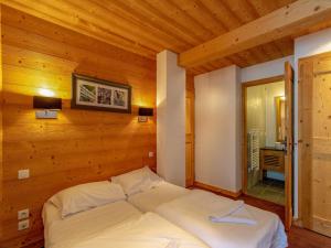 a bed in a room with a wooden wall at Snowy Escape in Scenic Vallorcine in Vallorcine +32 photos