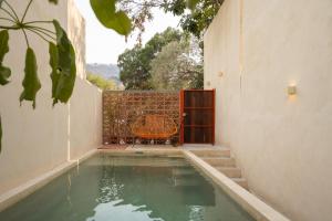 a house with a swimming pool next to a wall at Casa Oma 04 in Tepoztlán