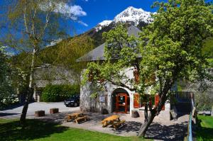 a building with a snow covered mountain in the background at Auberge La Cure in Oz