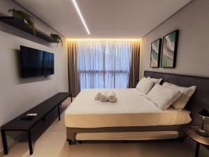 a bedroom with a large bed with two towels on it at Flats pé na areia Alta Garden in João Pessoa