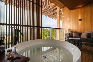拉古洼Hotel Indigo Bintan Lagoi Beach by IHG的带阳台的客房内的浴缸