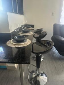 a black table with plates and wine glasses on it at Encanto Moderno en Punta Cana in Punta Cana