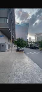 a city street with a tree and a building at Élégance Urbaine Casa Finance city in LʼOasis