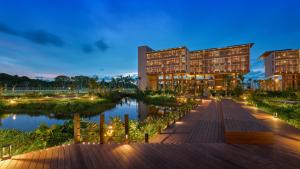 拉古洼Hotel Indigo Bintan Lagoi Beach by IHG的夜晚校园的效果图，有河流和建筑物