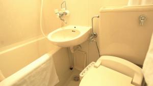 a small bathroom with a toilet and a sink at 美祢グランドホテル in Mine