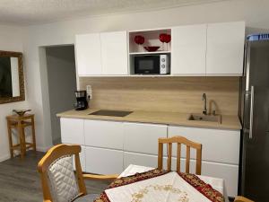 a kitchen with white cabinets and a microwave at Holiday home Balatonbereny 9 in Balatonberény +11 photos