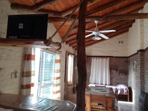 sala de estar con ventilador de techo y cama en Cabañas Rayuela y otros cuentos, en Santa Rosa de Calamuchita