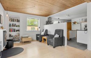 a living room with two chairs and a table at 4 Bedroom Amazing Home In Østermarie in Østermarie