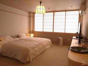 una camera da letto con un grande letto bianco e un lavandino di Ayameya Ryokan a Nakanojo Altre 40 foto