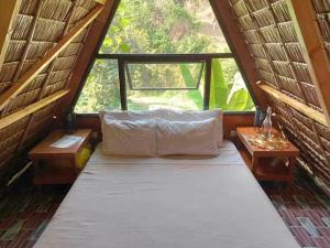 a bed in a room with a large window at The Secret Hut in Cebu City