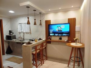 a kitchen with a bar with a tv on the wall at Flat Sognare Due in Santa Teresa