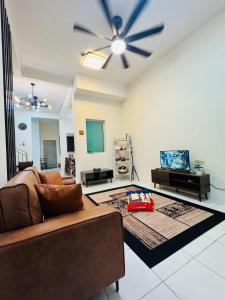 a living room with a couch and a ceiling fan at asaha homestay in Kepala Batas