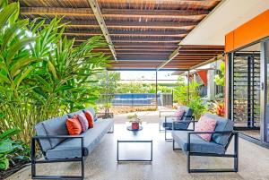 a patio with couches and a table and plants at Tropic Pavilion - Breezy Designer Retreat near Beach in Paraparap